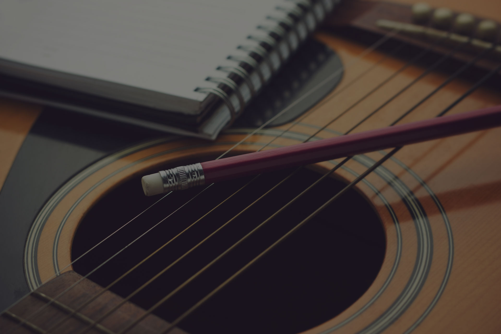 Notebook and pencil on guitar