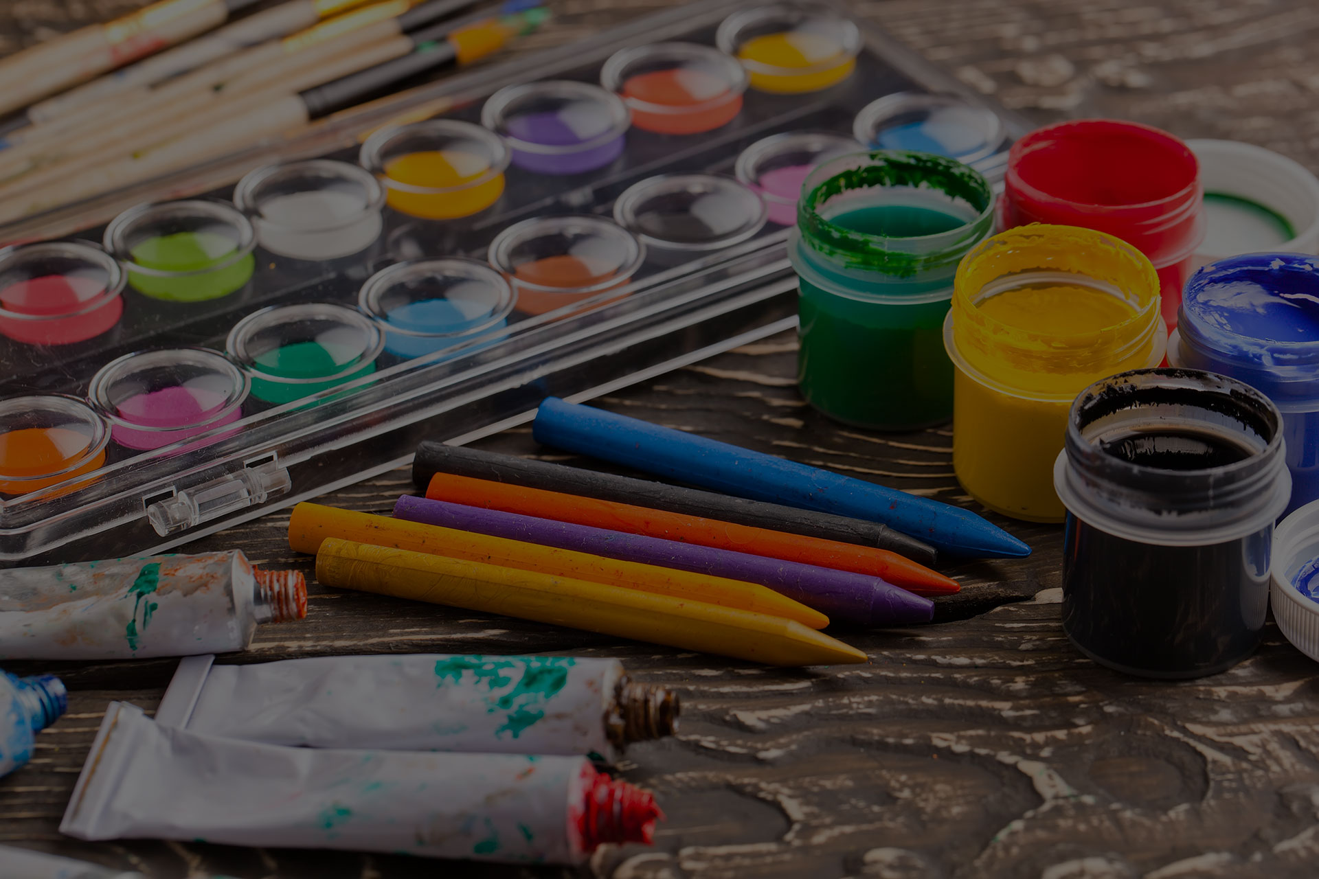 Paint brushes and paint on an old background in a composition on a table